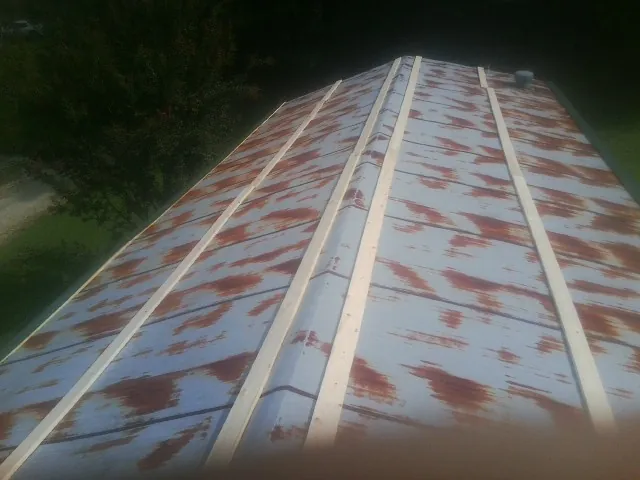 Rusted metal roof panels with new wood purlins before replacement — Storm Damage Roof Repair in Melissa by Roofing Brothers