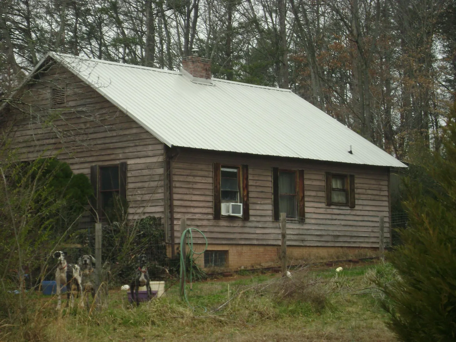 White metal roof on an old wood sided farmhouse, from a Asphalt Shingle Roof Repair job in Melissa